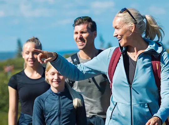 Bilden visar en familj som är ute och fjällvandrar.