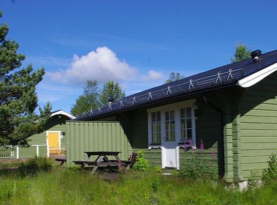 I populära Gröna Byn är det barnvänligt och mysigt för den lilla familjen. Bilden visar några hus i Gröna Byn med grönt gräs vid sidan av.