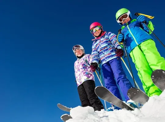 Bilden visar tre glada barn i backen