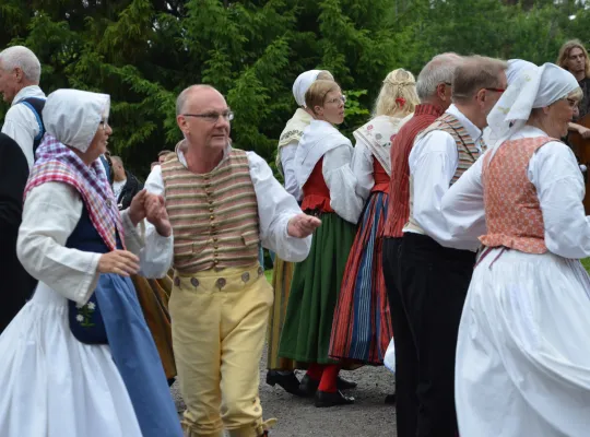 Bilden visar en man som deltar i midsommardans