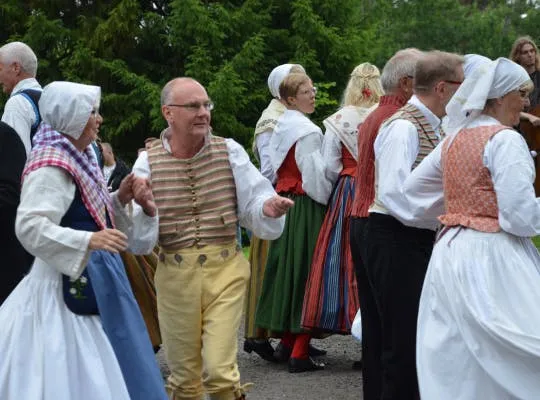 Bilden visar en man som deltar i midsommardans