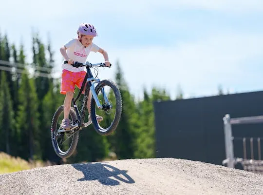 Bilden visar ett barn som cyklar på en pump track-bana i Hafjell