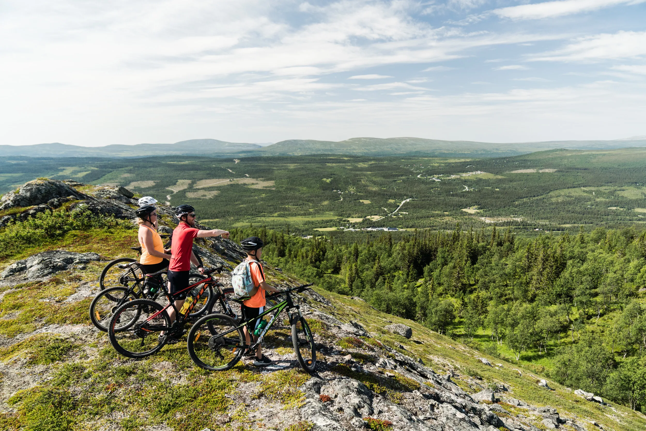 Bilden visar tre cyklister som blickar ut över landskapet i Funäsdalsberget