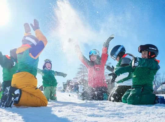 Bilden föreställer en skidlärare och glada barn